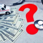 A toy ambulance and stethoscope sit atop 100-dollar bills to stress how a reference-based pricing model could mean significant savings for your company.