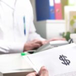 A patient reviews a medical bill with a giant dollar sign to illustrate the benefits of choosing RBP vs PPO