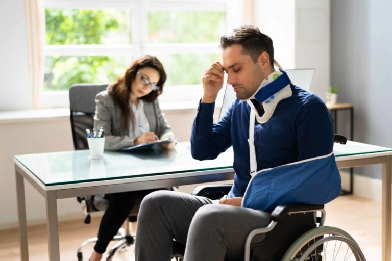 A frustrated patient in a wheelchair and arm sling tries to make sense of a medical bill, highlighting the importance of claim editing